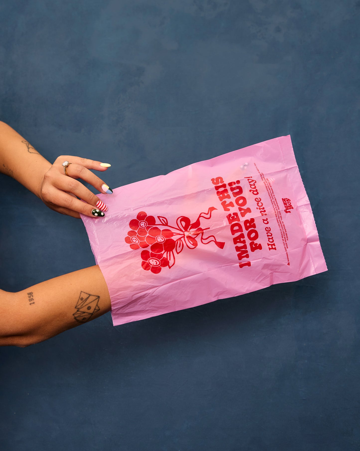 Pink poop bag with red text and floral bouquet illustration that reads 'I made this for you! Have a nice day.'