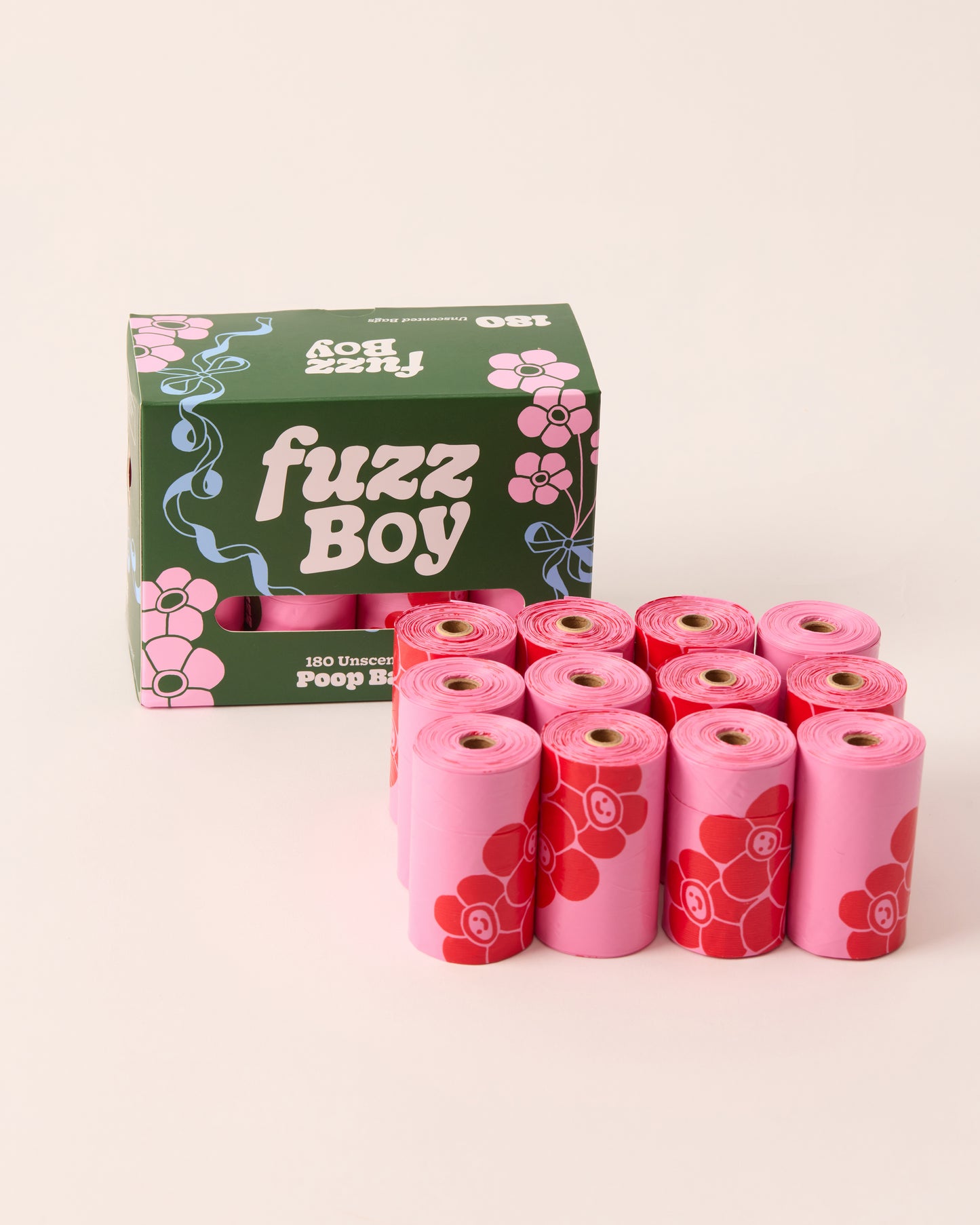 12 rolls of pink dog waste bags with red floral design. They appear next to green Fuzzboy packaging.