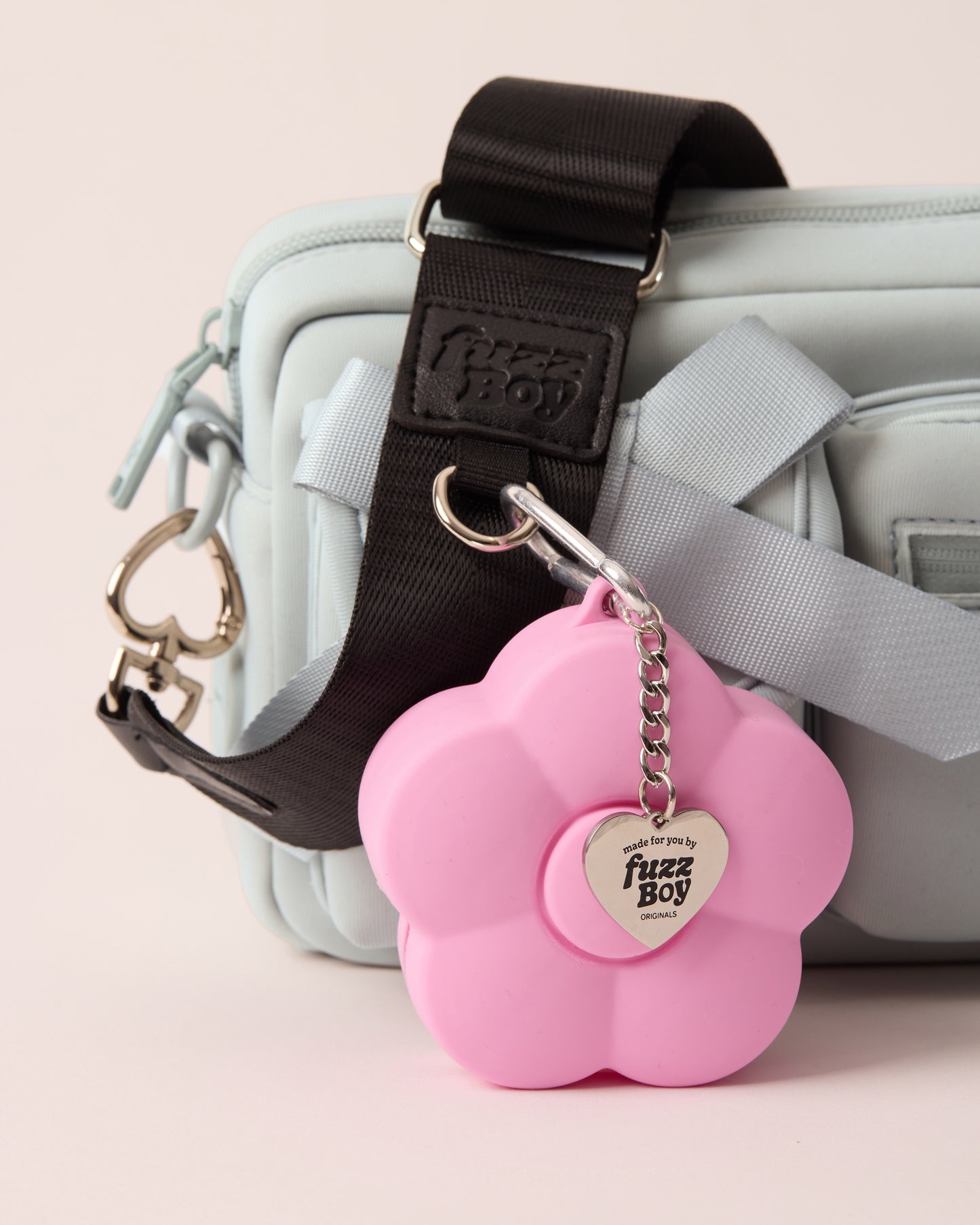 Pink flower-shaped treat pouch attached via a D-ring on the Fuzzboy blue walking bag strap.