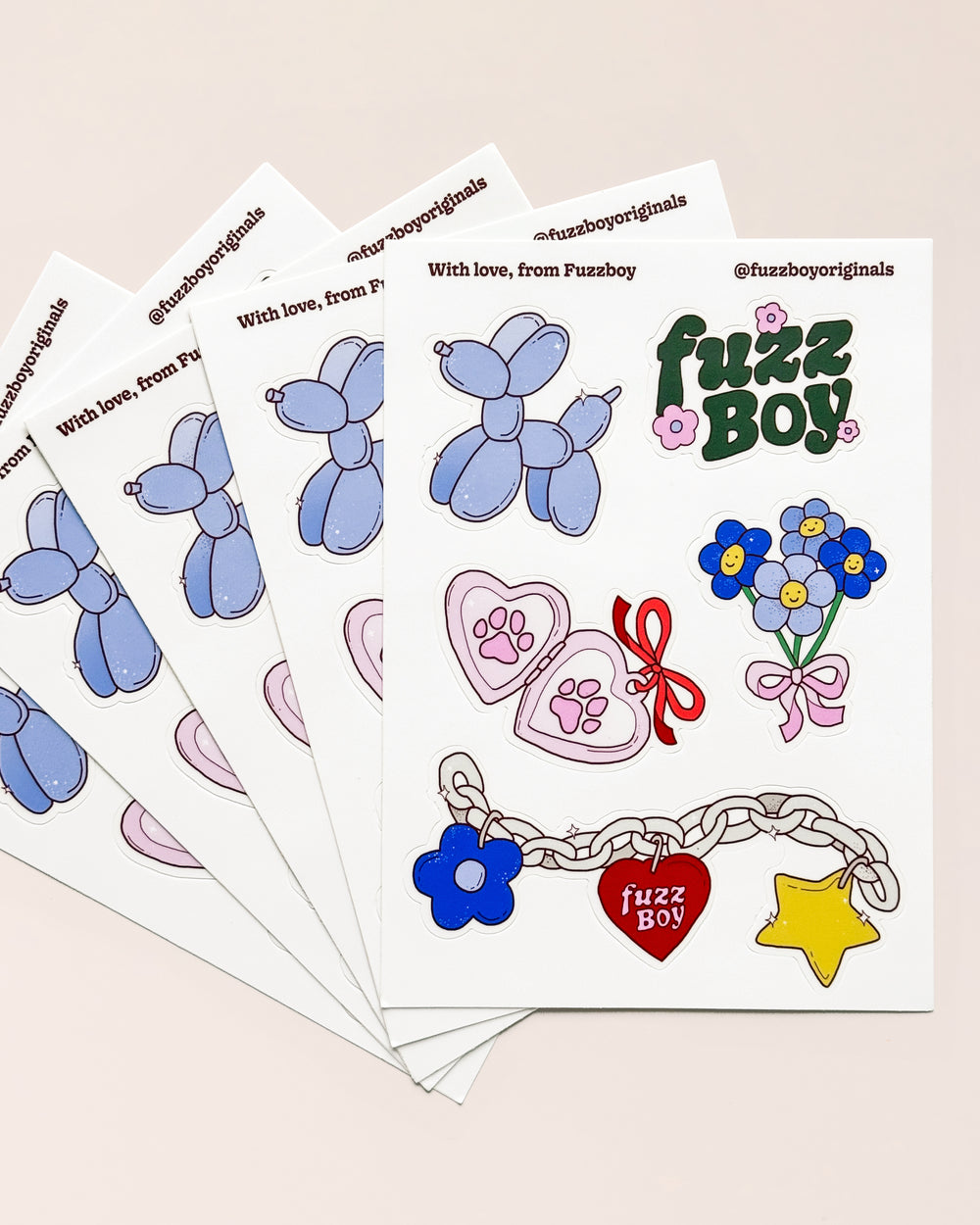 Sticker sheet with various designs including a blue balloon dog, Fuzzboy logo, bouquet of flowers, heart-shaped locket with pawprints, and a chain with charms.