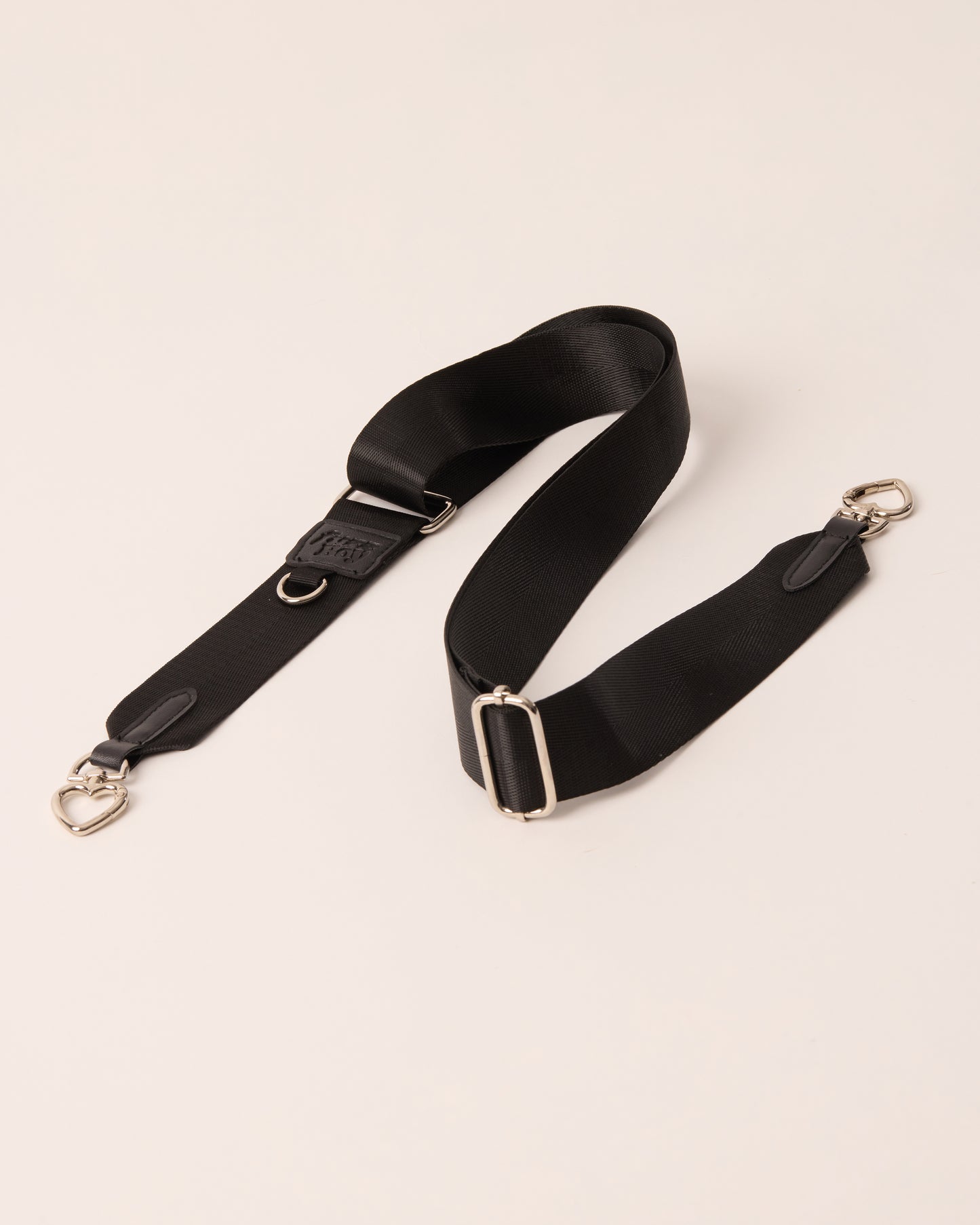 Black detachable and adjustable strap with silver hardware. 